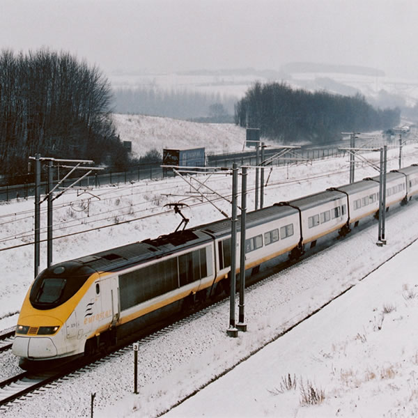 train moving through snow on the train tracks to the alps